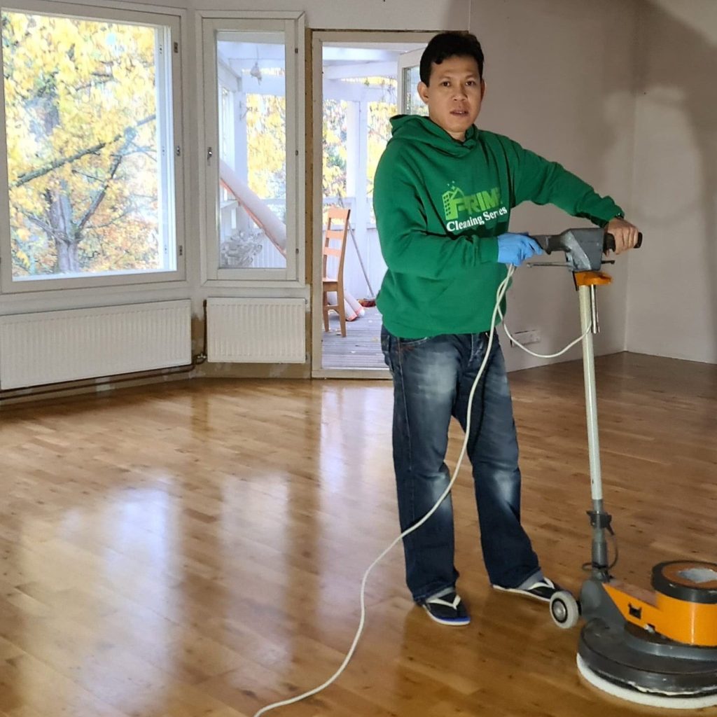 Prime Cleaning team member operating a floor polisher in a bright Helsinki room